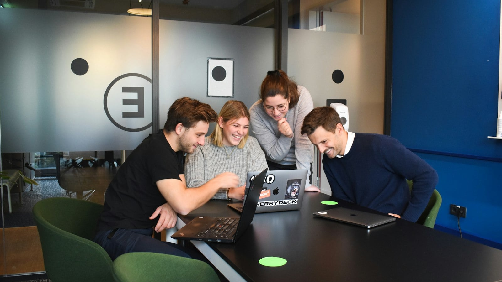 Agency team gathered around a laptop in a meeting
