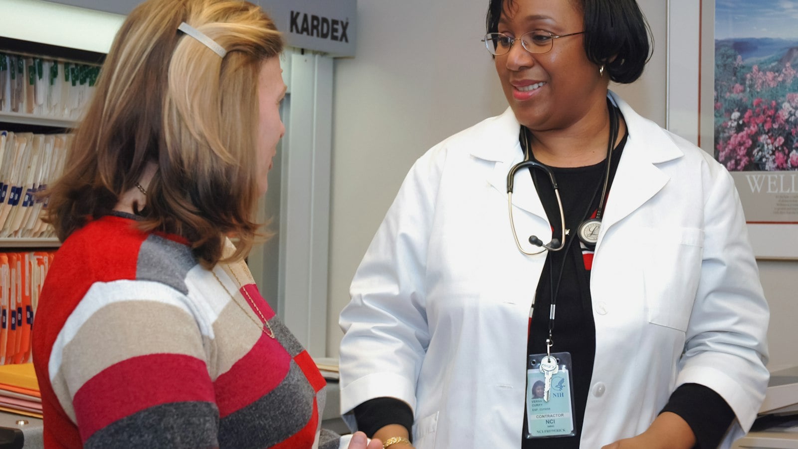 Black woman doctor speaking with a patient